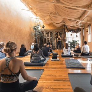Yoga-Gruppe in einem Studio bei Hatha oder Yin Yoga als Praxis zur Stressregulation, Achtsamkeit und Resilienz-Entwicklung.